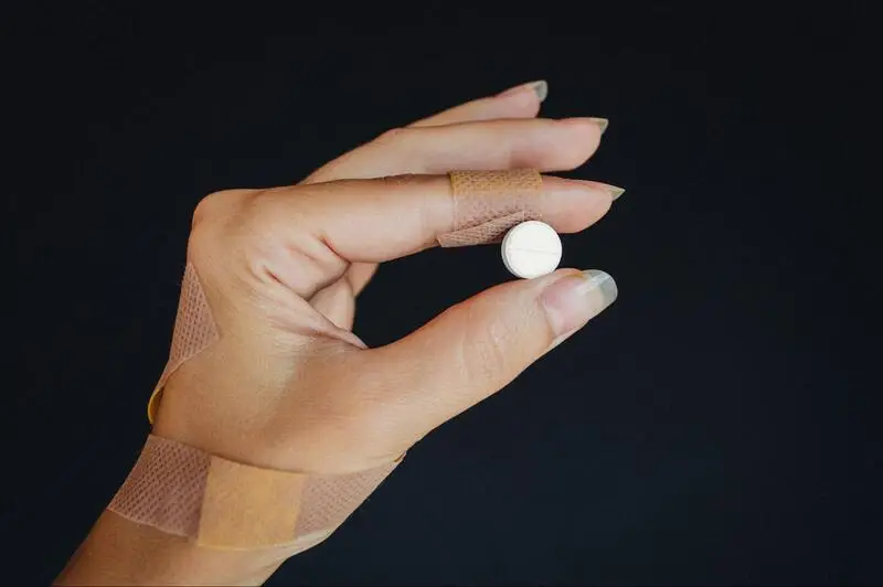 a female hand holding a pill is tramadol an opioid