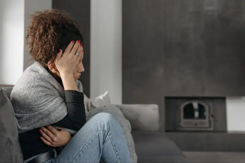a stressed woman sitting on a sofa