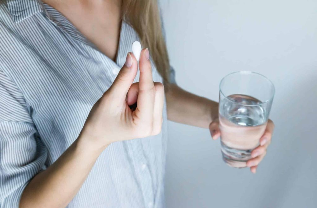 woman about to take a painkiller