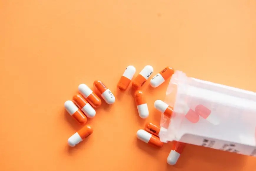 spilled pills on an orange surface
