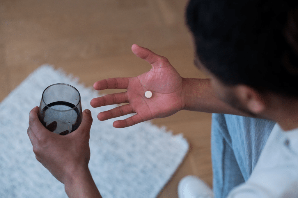 a man holding a pill in one hand and a glass of water in the other
oxycontin addiction