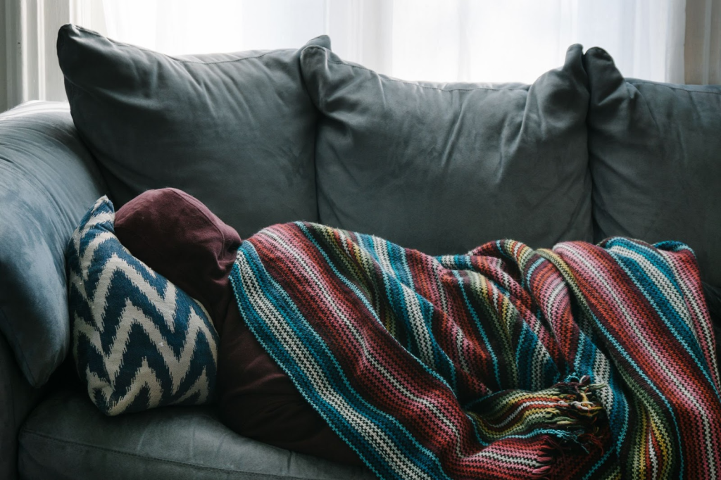 a sickly man lying on a sofa covered with a blanket due percocet addiction