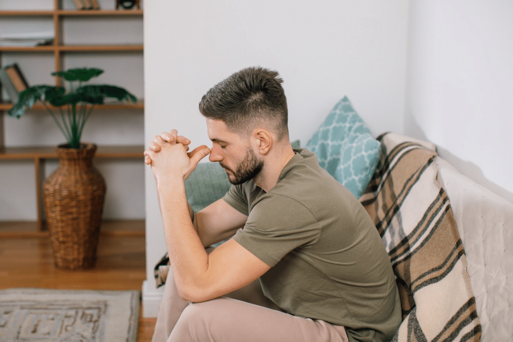 a stressed man sitting on a sofa in the living room