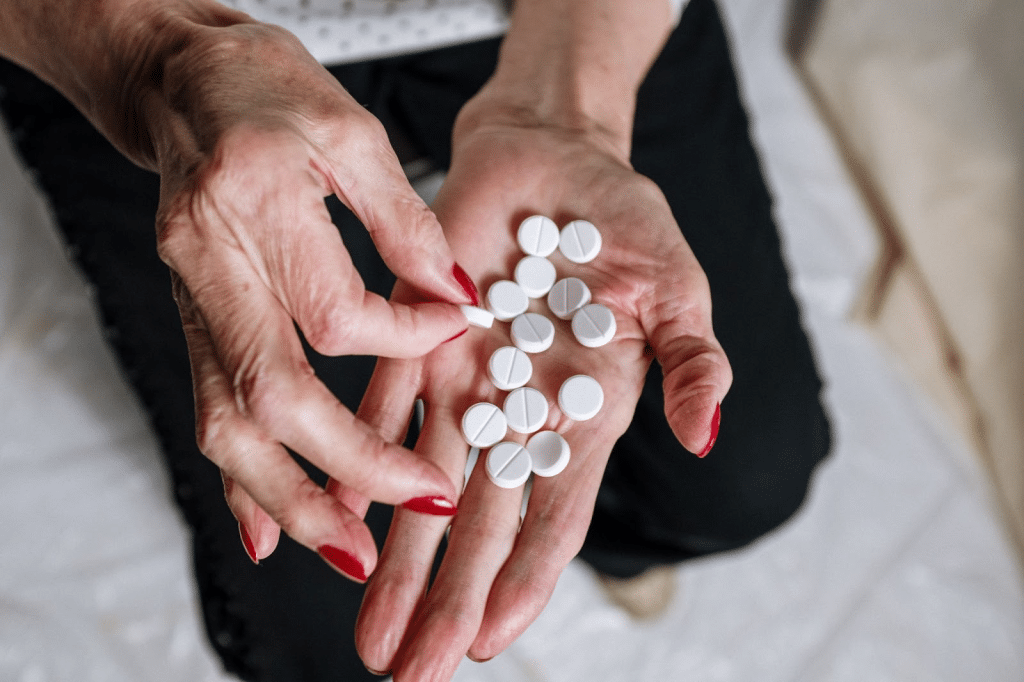 an elderly woman's hands holding a lot of white pills
percocet and alcohol