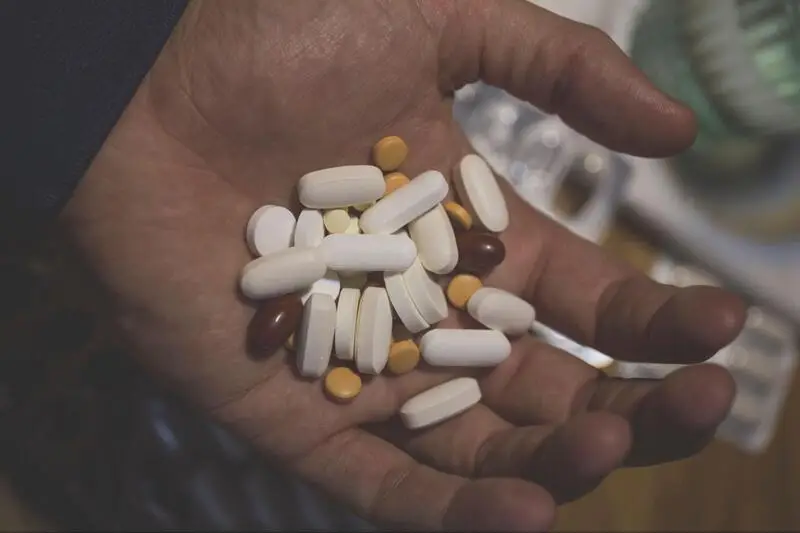 a male hand full of pills