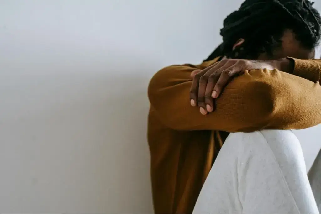 Man sitting with his head resting on his arms