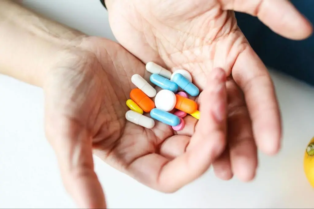 a man holding pills in his palms