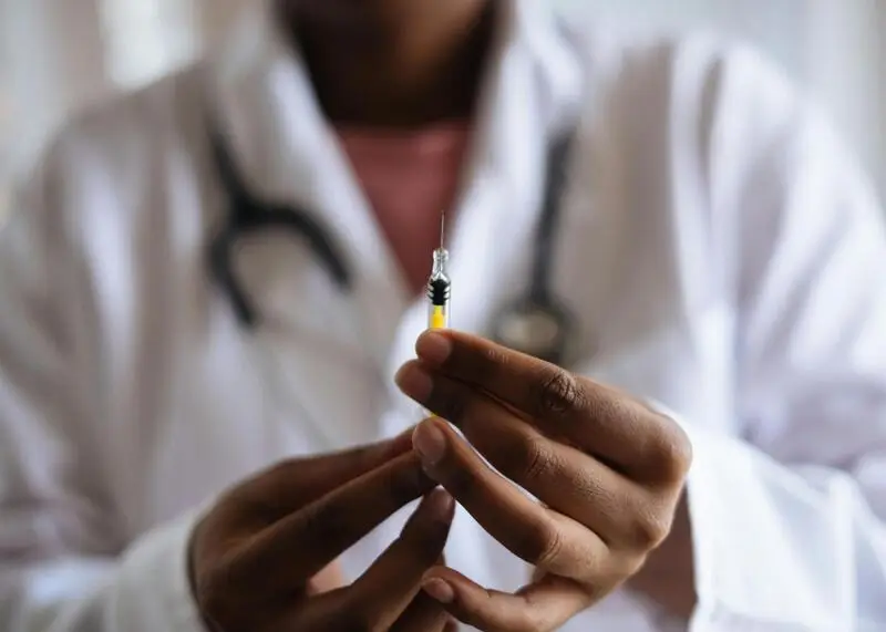 Doctor holding a filled syringe, preparing for an injection