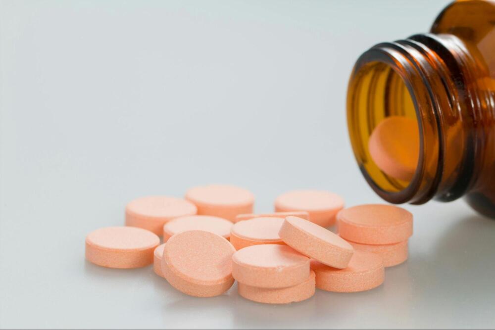 Orange-colored medicine spilling out of a bottle