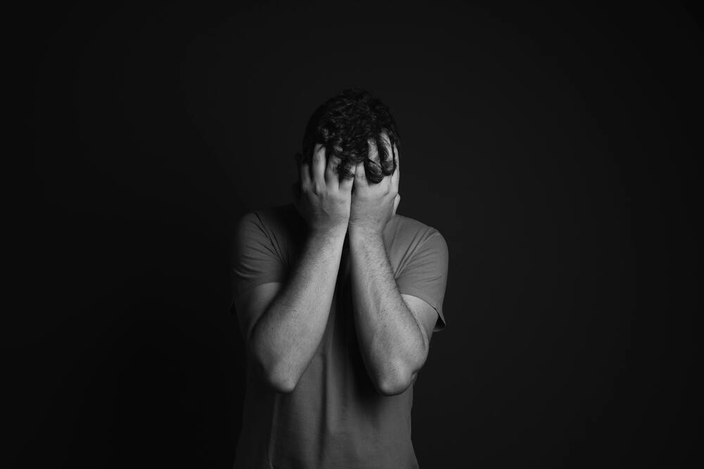 A man holding his head in his hands in distress